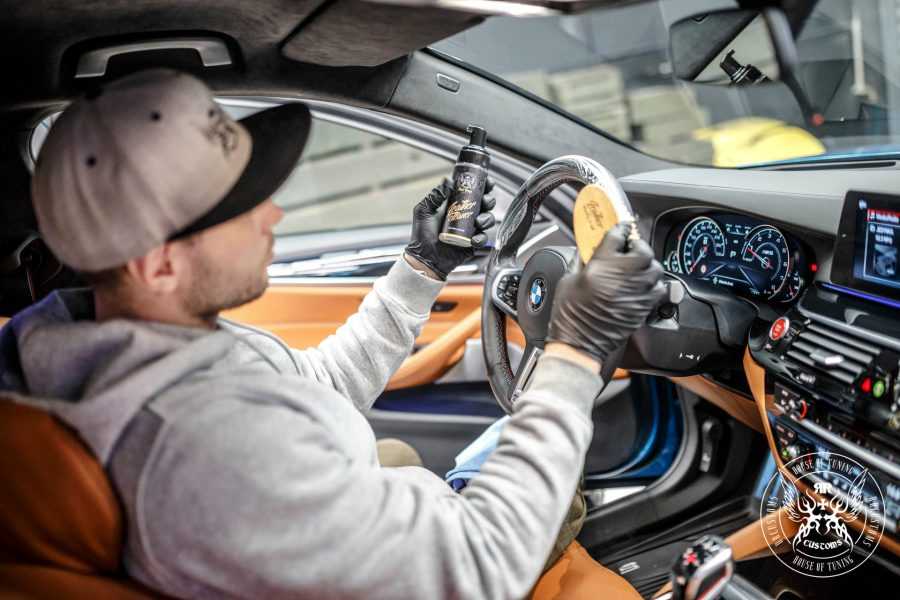 Detailer aplicando Leather Care PRO Strong en el salpicadero y volante del coche